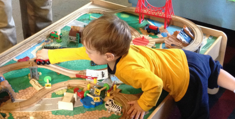 little boy playing with model train